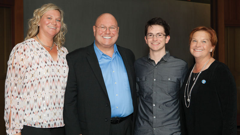 Skaggs family members Jennifer Benardoni (left), Mark Skaggs (center left), and Claudia Skaggs Luttrell (right) with Michael Bird (center right), a recipient of an endowed fellowship supported by the family. 